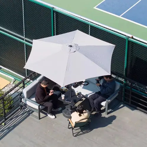 Juego de terraza para exterior con sombrilla y cuatro sillas.